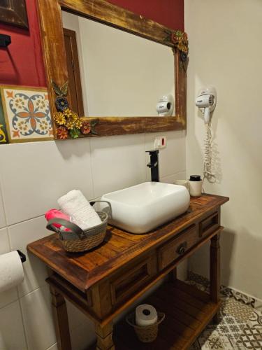 a bathroom with a white sink and a mirror at Pousada de Charme Emirados in Ilhabela