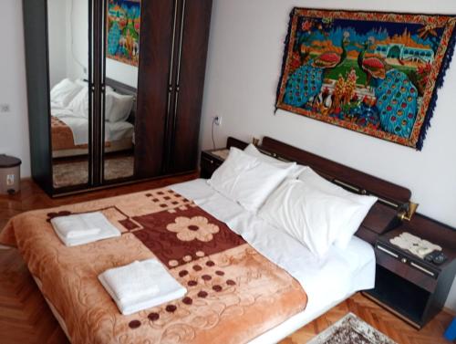 a bedroom with a bed with a mirror on the wall at BoHan sobe Vladičin Han in Vladičin Han