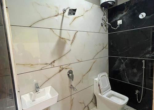 a bathroom with a toilet and a sink at Near Mahakal Temple BUDGET HOTEL V R , UJJAIN, Fully Air conditioned Rooms with Wifi and Parking, Best Hotel IN Ujjain in Ujjain