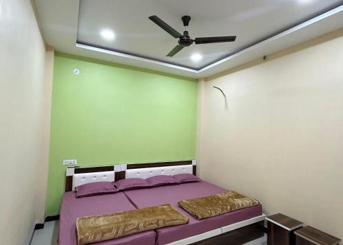 a bedroom with a ceiling fan and a bed with purple sheets at Near Mahakal Temple BUDGET HOTEL V R , UJJAIN, Fully Air conditioned Rooms with Wifi and Parking, Best Hotel IN Ujjain in Ujjain