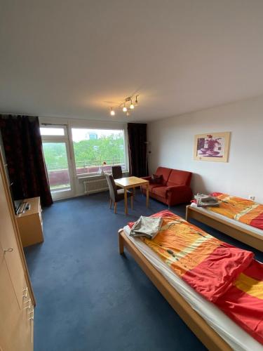 a room with two beds and a couch and a table at Panoramalounge 712 in Lahnstein