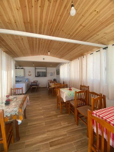 a dining room with wooden ceilings and tables and chairs at Vila Dura in Ksamil