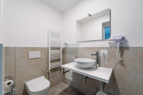 a bathroom with a sink and a mirror and a toilet at Franciacorta Rooms 1 in Corte Franca