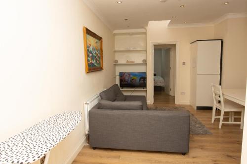 a living room with a couch and a table at Evergreen Apartments- Flat 2 in London