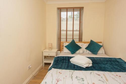 a bedroom with a bed with blue and white pillows at Evergreen Apartments- Flat 2 in London