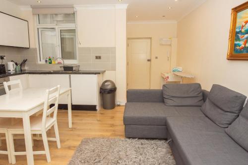 a living room with a couch and a table at Evergreen Apartments- Flat 2 in London