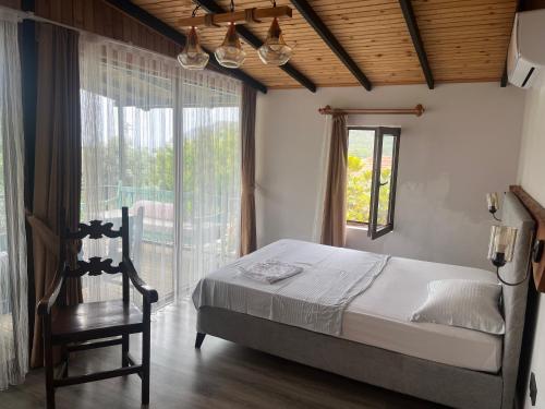 Un dormitorio con una cama, una silla y una ventana en Sayfiye Butik Otel, en Köyceğiz