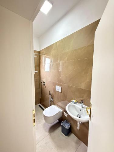 a bathroom with a toilet and a sink at GuestHouse Brahja, Tirana in Sauk