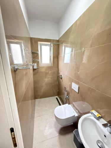 a bathroom with a toilet and a sink at GuestHouse Brahja, Tirana in Sauk