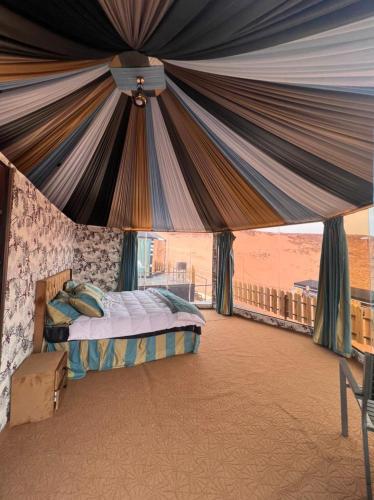 a bedroom with a bed under a tent at Rum Awaad luxury camp in Wadi Rum