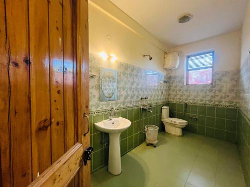 un baño con lavabo e inodoro en White villa cloud 9, en Manali