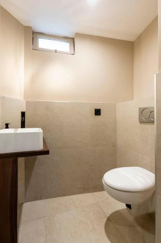 a bathroom with a white toilet and a sink at Loft Spacieux pour 10 personnes avec Terrasse in Nice