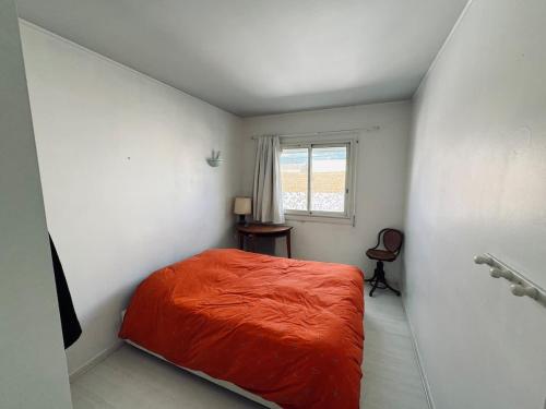 une chambre avec un lit orange et une fenêtre dans l'établissement Proche Plage 2 Chambres, à Valras-Plage