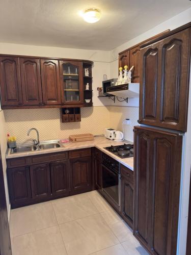 a kitchen with wooden cabinets and a stove top oven at Magnolia in Ljubuški