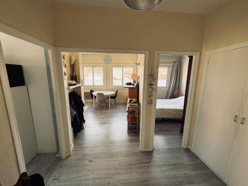 - un couloir avec une chambre dotée d'un lit et d'une table dans l'établissement Proche Plage 2 Chambres, à Valras-Plage