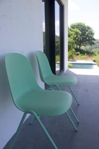 two green chairs sitting next to a window at Ripple Are Guling Beach, South Lombok in Kuta Lombok