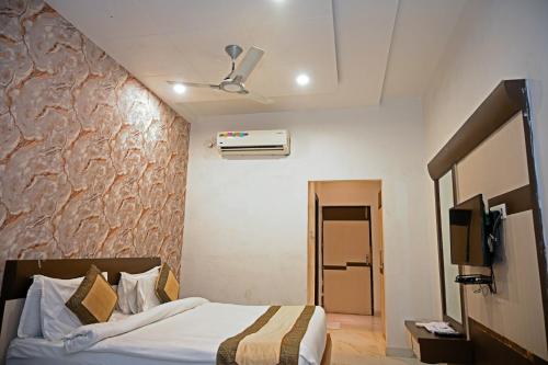 a hotel room with a bed and a tv at Homansh Krishna Palace in Gorakhpur