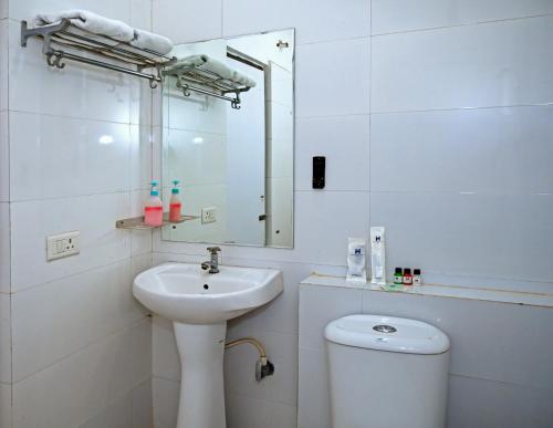 a bathroom with a sink and a toilet and a mirror at Homansh Krishna Palace in Gorakhpur