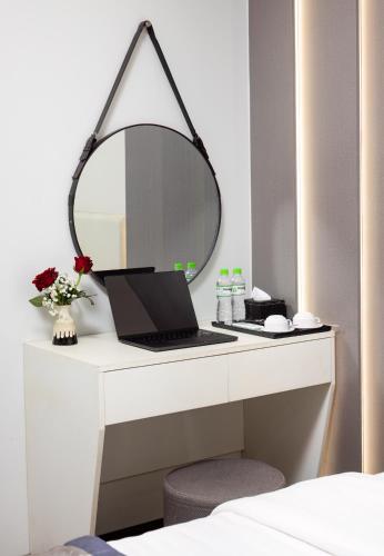 a desk with a laptop and a mirror on it at Cat Ba Seoul 2 Hotel & Apartment in Cat Ba