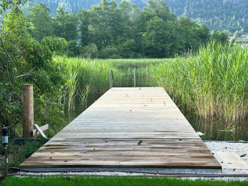 a wooden dock in the middle of a field at Camp O Lake Haus am See in Villach
