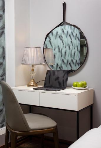a desk with a laptop and a lamp and a chair at Cat Ba Seoul 2 Hotel & Apartment in Cat Ba