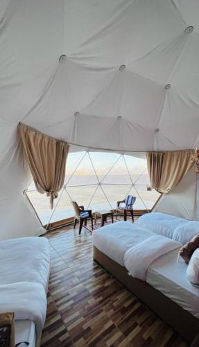 two beds in a room with a view of the ocean at Wadi Rum Desert Camp in Wadi Rum