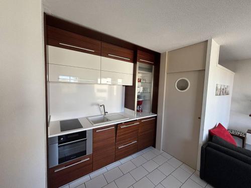une cuisine avec un évier et une cuisinière four supérieur dans l'établissement 2 Pièces Cabine avec Terrasse et Parking, 150m Plage - Argelès-sur-Mer - FR-1-388-79, à Argelès-sur-Mer