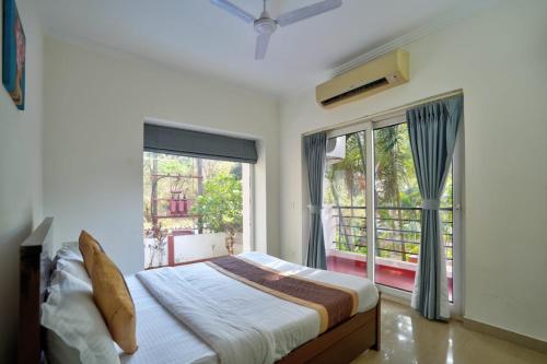 a bedroom with a bed and a large window at Luxury 3BHK Villa With Private Pool in Candolim in Nerul