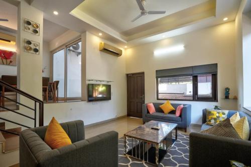 a living room with two couches and a tv at Luxury 3BHK Villa With Private Pool in Candolim in Nerul