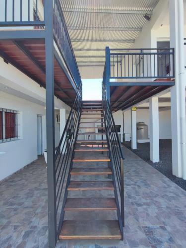 a staircase in a building with a metal railing at Alojamiento colibrí in La Porteña
