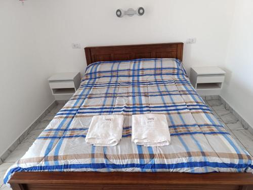 a bed with two white towels on top of it at Alojamiento colibrí in La Porteña