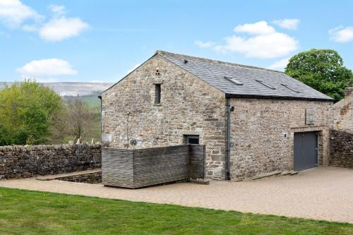 an old stone building with a stone wall at Hawks Barn - Horton in Ribblesdale in Horton in Ribblesdale