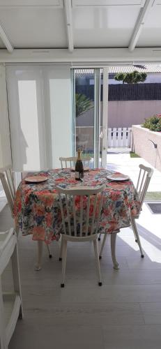 - une table à manger avec une toile de table fleurie dans l'établissement Maison Les Sables D'olonne, à Les Sables-dʼOlonne