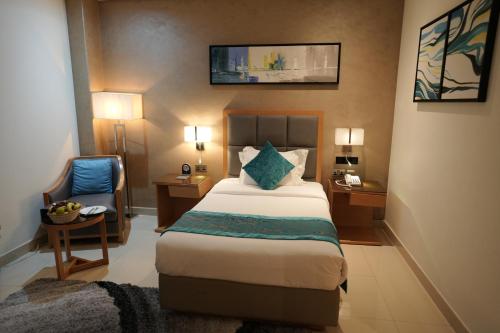 a hotel room with a bed and a chair at Meshal Hotel in Manama