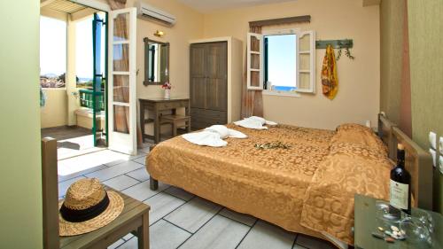 プラカにあるAngeliki Apartmentsのベッドとバスルーム付きのホテルルームです。