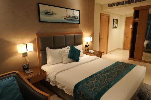 a hotel room with a large bed with two lamps at Meshal Hotel in Manama