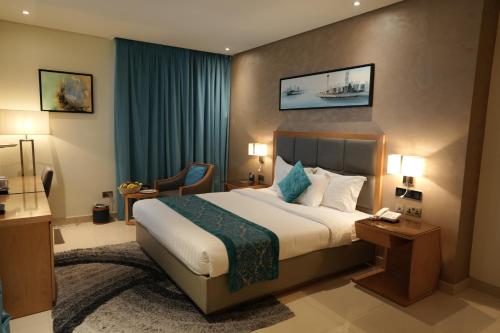 a hotel room with a large bed and a chair at Meshal Hotel in Manama