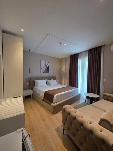 a hotel room with a bed and a couch at Orik Hotel & Spa in Vlorë