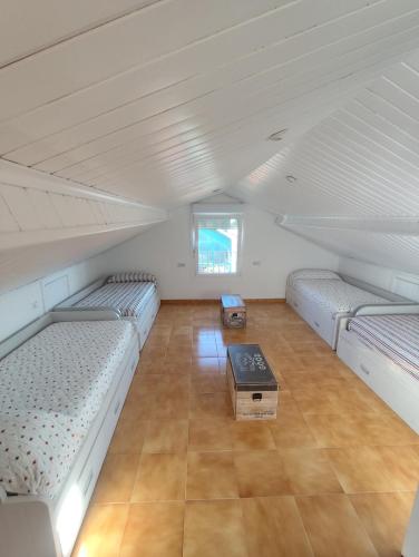 a attic room with two beds and a table at Casa O Castriño in Cambados