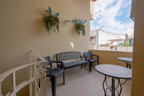 a balcony with tables and chairs and a bench at La Casa con il Cuore in Brindisi