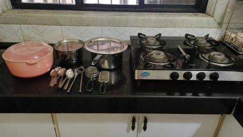 una estufa con ollas, sartenes y utensilios en Hill View Quads Villa, en Lonavala