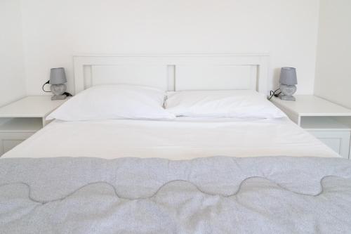 una camera con un letto bianco e 2 mensole bianche di Francesco&Chiara - Sweet Apartment a Chioggia