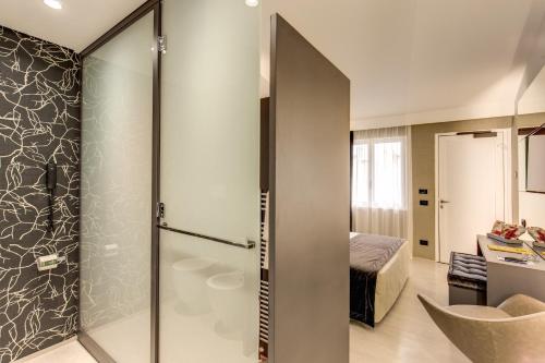 a bathroom with a shower and a bedroom at Motel Rona in Caponago