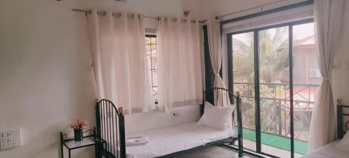 una cama en una habitación con una ventana grande en Hill View Quads Villa, en Lonavala