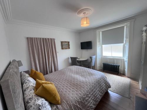a bedroom with a bed and a window and a desk at The Old School House in Bristol