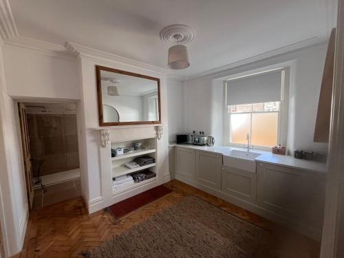 a bathroom with a sink and a mirror and a window at The Old School House in Bristol
