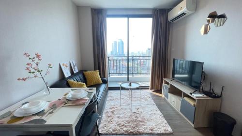a living room with a couch and a tv at 曼谷繁华地区公寓 免费上网 家居家电齐全 in Ban Na Song