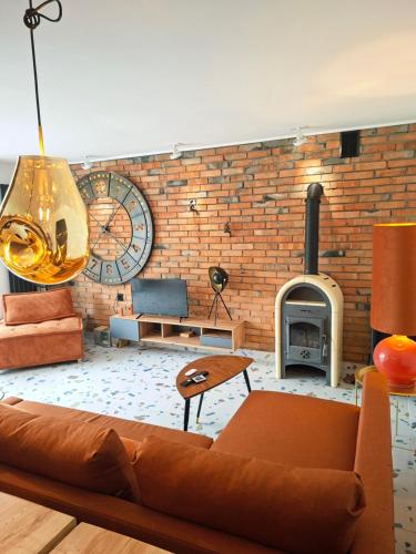 a living room with a couch and a brick wall at Marcowe Kąty-Przestrzeń na wypoczynek, odpocznij w ciszy i naturze, tylko 7 minut od Sandomierza in Sandomierz