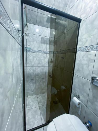 a bathroom with a glass shower with a toilet at Pousada Flor de Lis in Diamantina