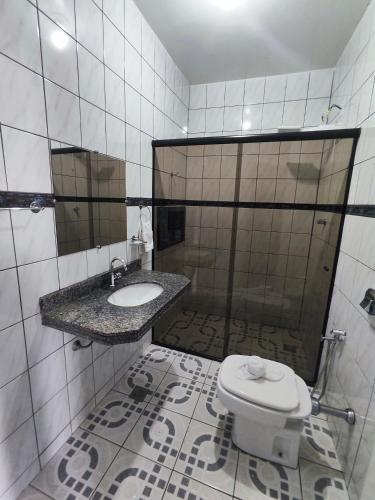 a bathroom with a toilet and a sink and a shower at Pousada Flor de Lis in Diamantina